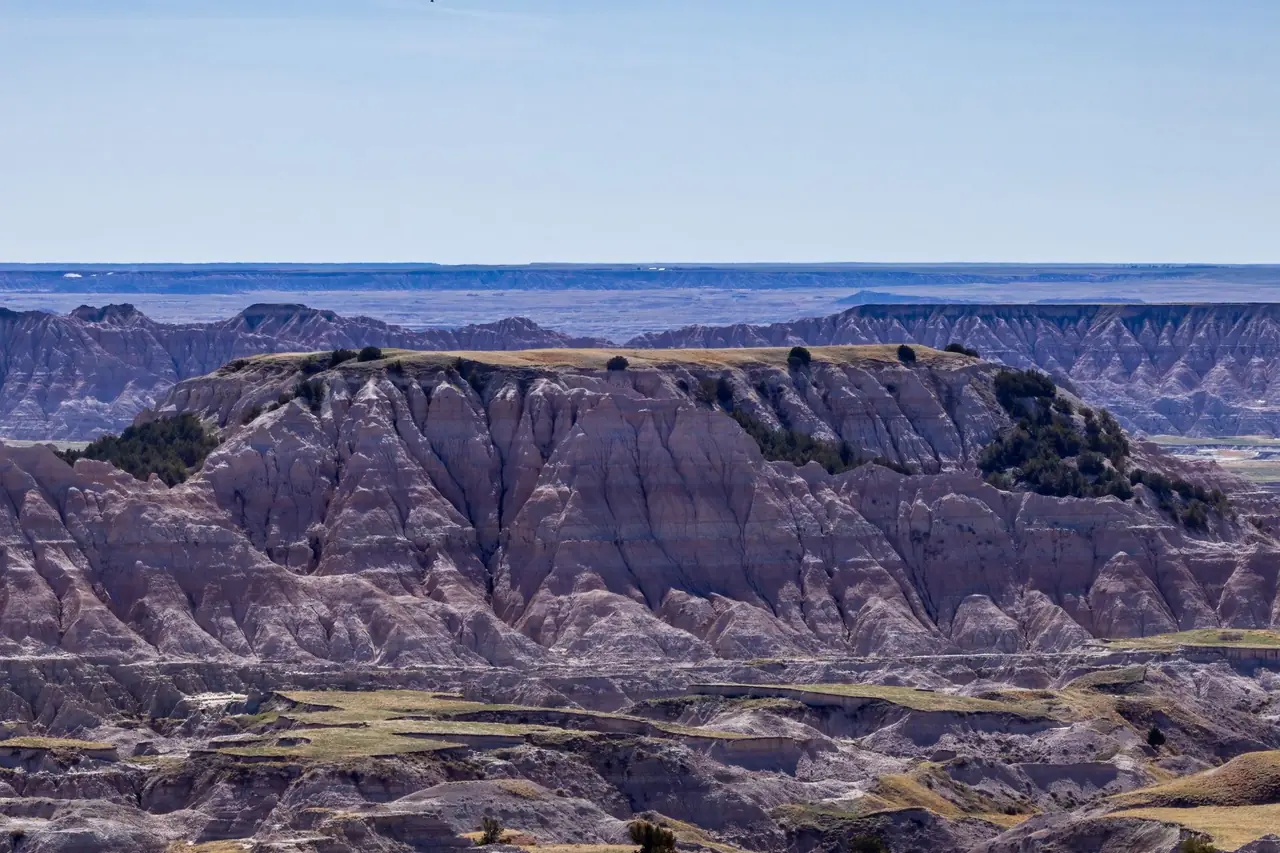 Eroded, striped buttes and ridges of the Badlands Wall stretching toward the prairie horizon in Badlands National Park