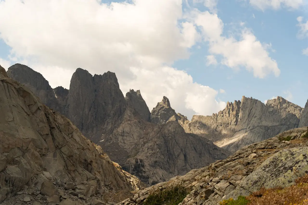 Jagged granite peaks and rocky alpine terrain under billowing clouds in the Wyoming high country