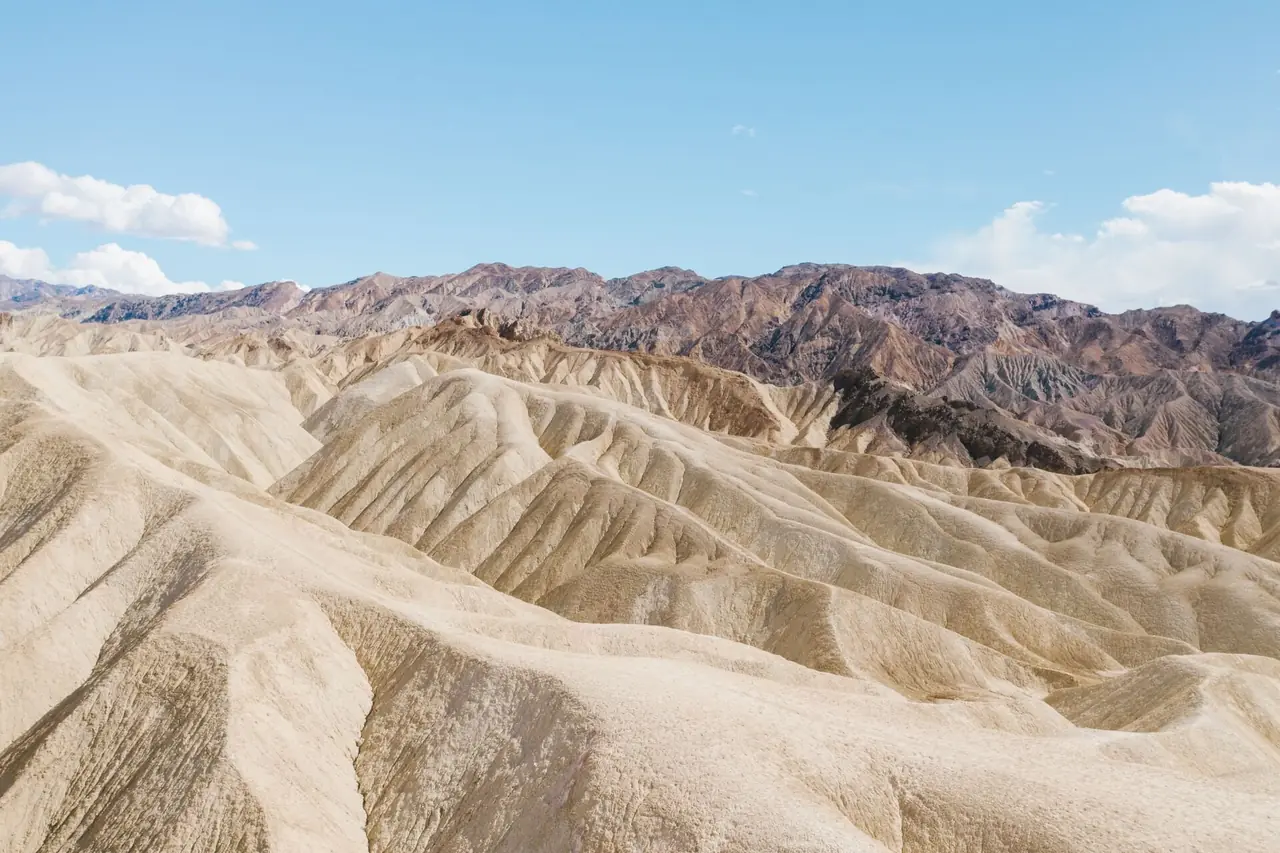Rippled, eroded badlands at Zabriskie Point with rugged mountains behind, Death Valley National Park