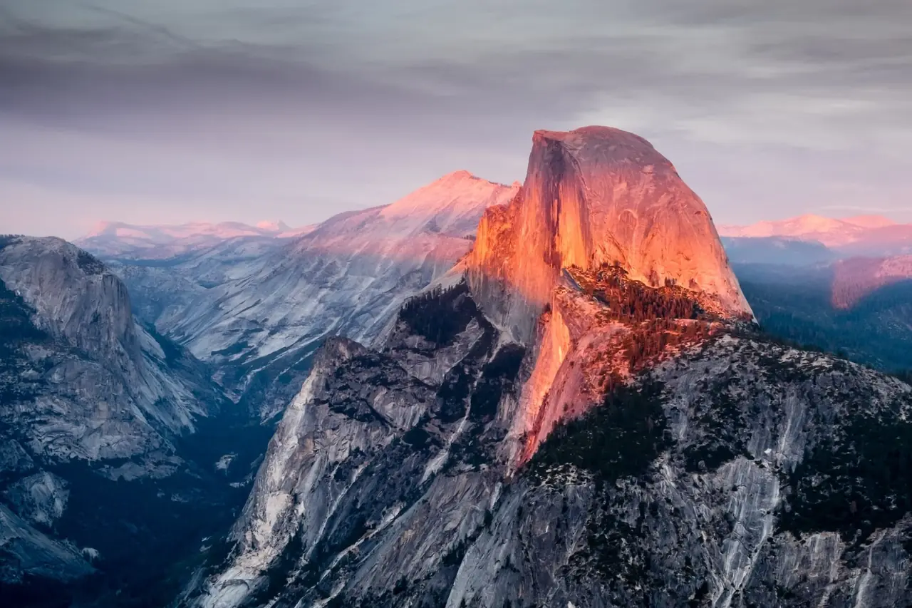 Half Dome glowing orange in sunset alpenglow above the granite cliffs of Yosemite Valley, Yosemite National Park